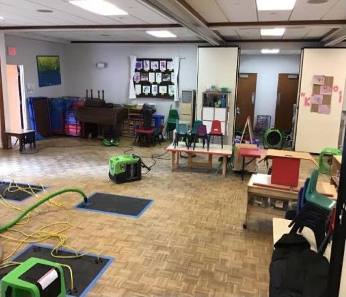 green SERVPRO equipment and drying mats in building