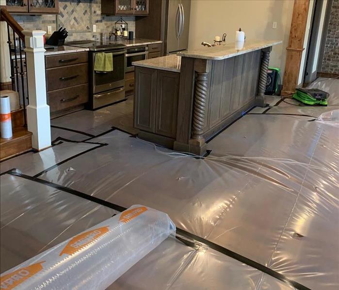 poly tending on wood floor showing kitchen area