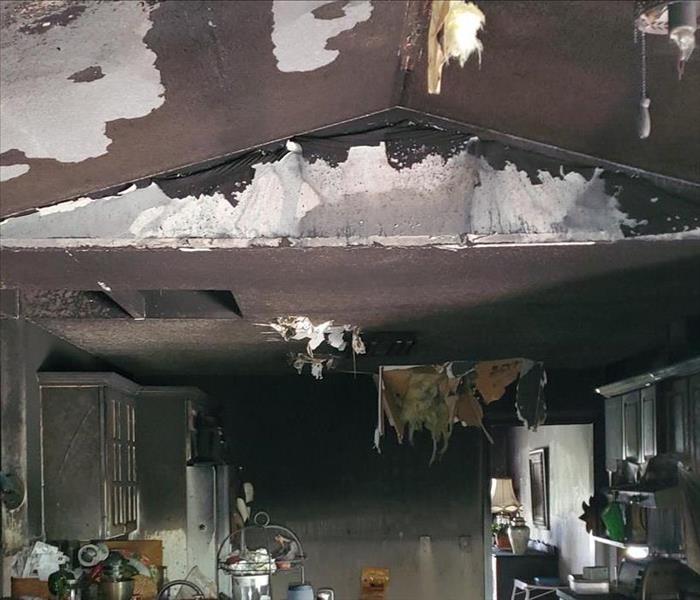 fire damaged kitchen, hanging debris from ceiling, soot on walls