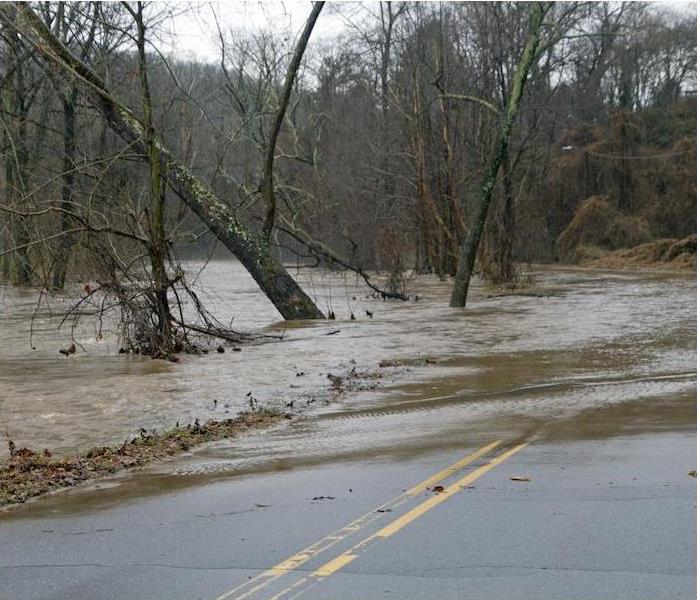flooded water running over blacktop road