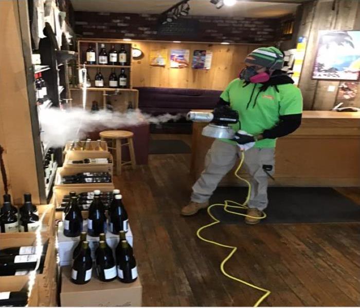 technician spraying wine bottles in wine shop