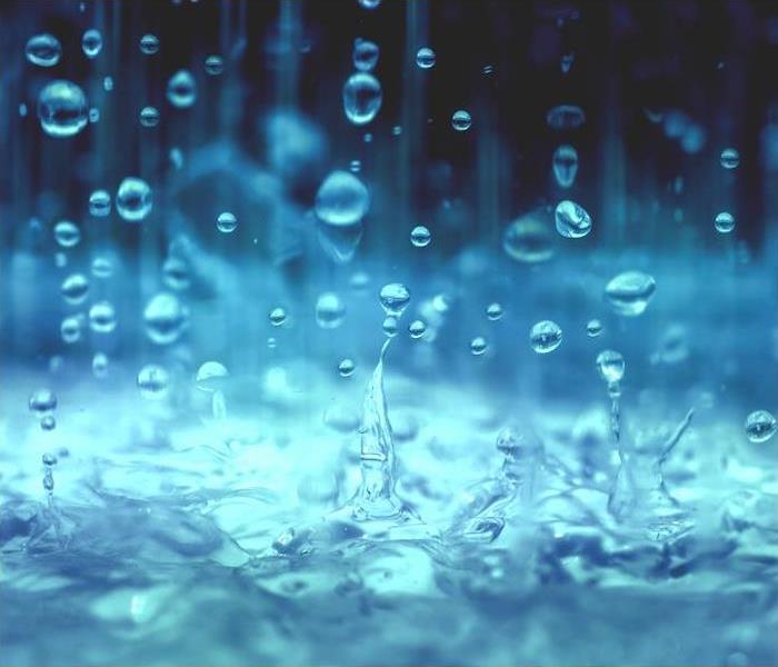 bright blue rain splashing into a pool of water